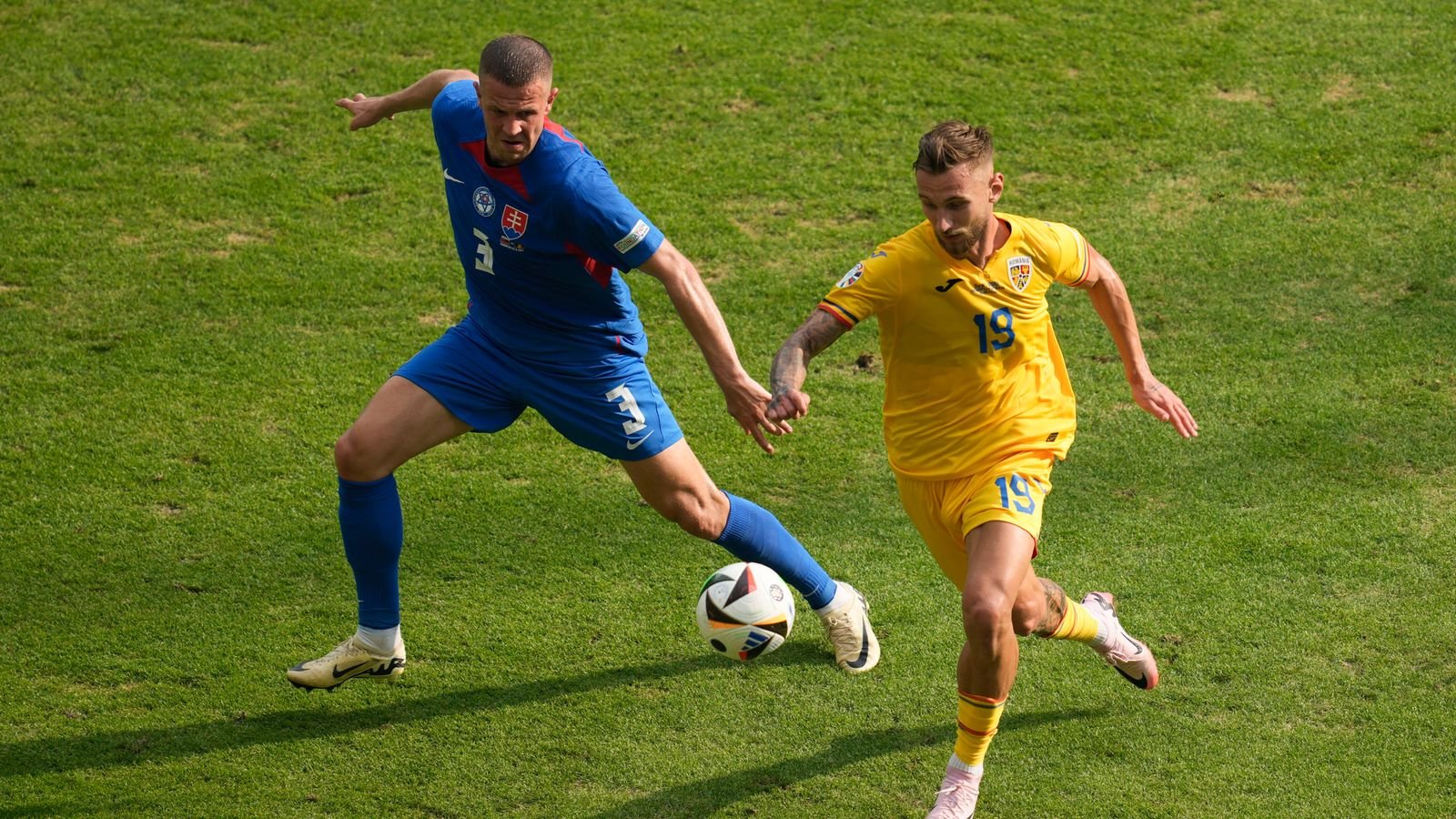 Romania's Denis Dragus, right, and Slovakia's Denis Vavro vie for the ball during a Group E match at the Euro 2024 soccer tournament in Frankfurt, Germany, Wednesday, June 26, 2024. (AP Photo/Darko Vojinovic)