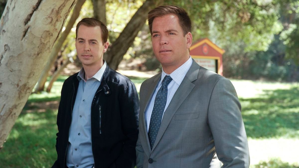Sean Murray and Michael Weatherly standing underneath tree in NCIS episode
